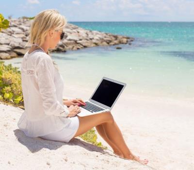 Businesswoman working with computer on the beach Businesswoman working with laptop computer on the beach.