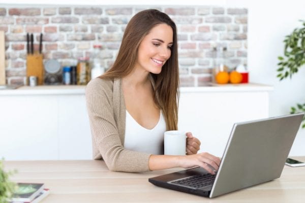 beautiful young woman using her laptop kitchen 1301 7666 e1567255648859